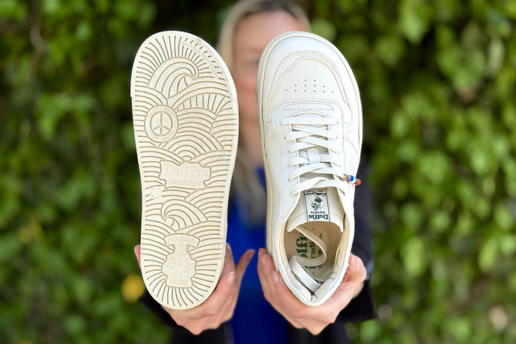 Person holding barefoot sneaker to show sole pattern