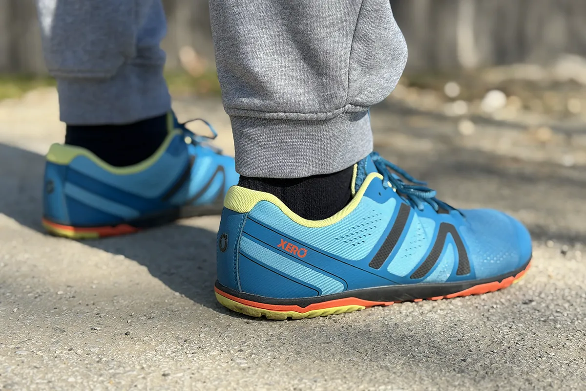 Blue barefoot running shoes worn outdoors, side view