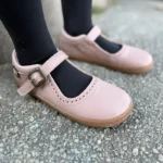 Pink barefoot Mary Jane shoes worn outdoors
